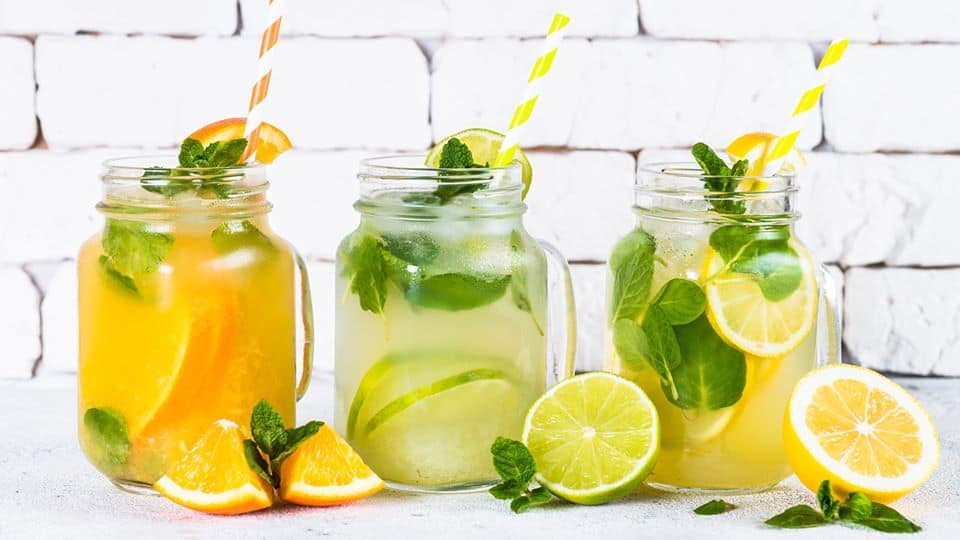 Mason jars filled with summer drinks and paper straws