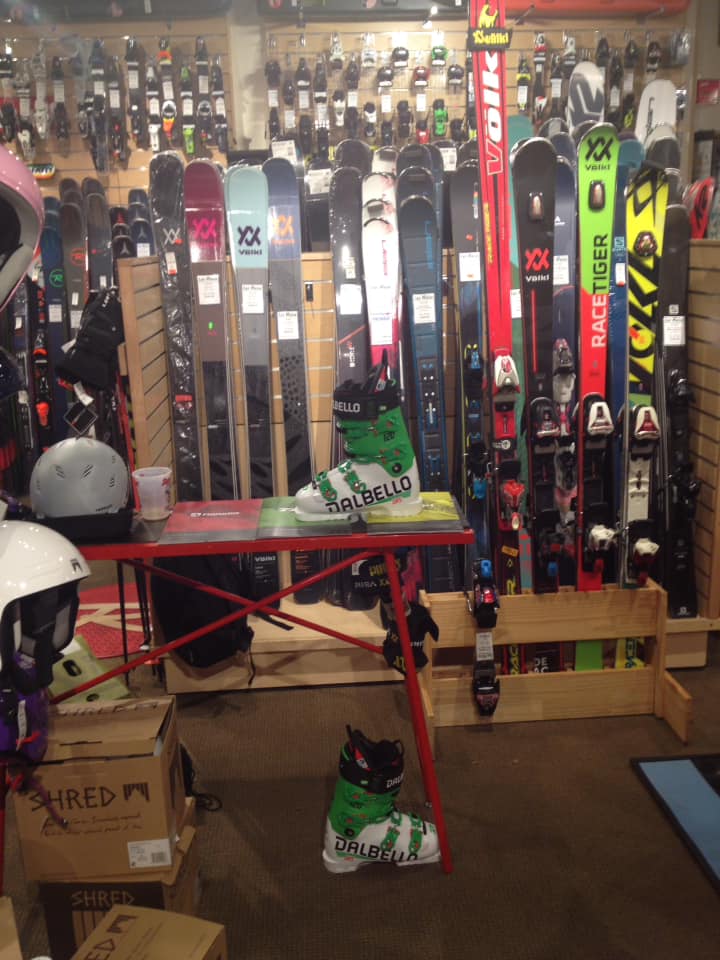 Winter skis against a wall with ski boots in front