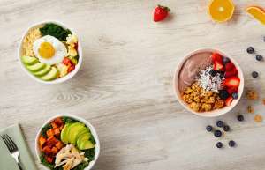 3 White bowls filled with fruit, salad and eggs
